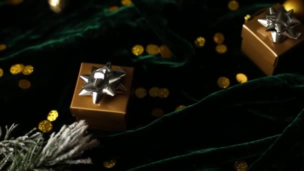 Rotacja Złote pudełka upominkowe ze srebrną wstążką na białym welurowym zielonym tle, z dekoracjami świątecznymi, Flat lay. Odbiór. Wesołych Świąt - Materiał filmowy, wideo