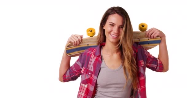 Porträt eines lächelnden Millennial-Mädchens, das mit Skateboard auf den Schultern im Studio mit Kopierraum posiert. Porträt einer lachenden Skaterin mit Skateboard auf weißem Hintergrund mit Copyspace. 4k - Filmmaterial, Video