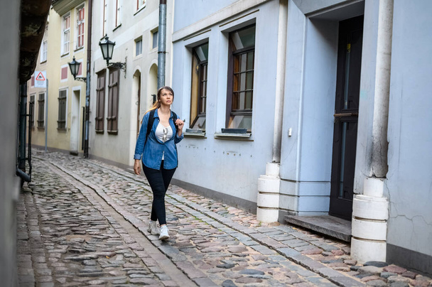 stilvolle Touristin spaziert durch die alte Straße einer antiken europäischen Stadt. - Foto, Bild