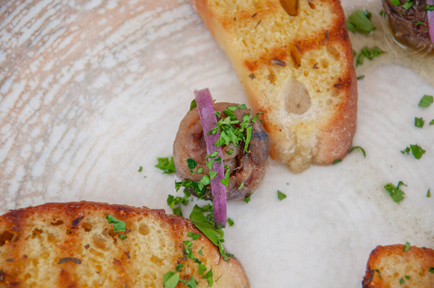 Роллированные анчоусы. Жареный хлеб ломтики с оливковым маслом, травы и рулонные анчоусы. Анчоусы в испанском баре - Фото, изображение