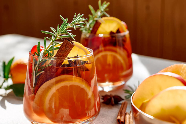 Mulled wine or christmas sangria with aromatic spices, apple, cherry and citrus fruits. Traditional Christmas festive warming spiced drink with orange, berry, cinnamon, cardamom and anise. - Photo, Image