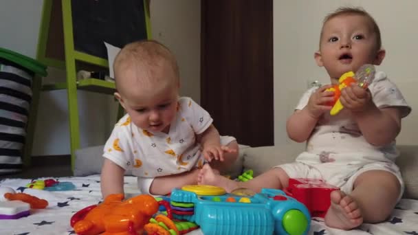 Hermanas gemelas fraternales, jugando con juguetes en el suelo en casa - Metraje, vídeo