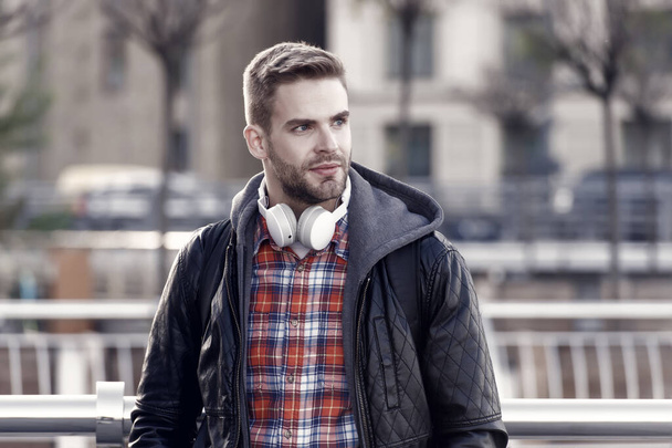 Streaming services concept. Modern people lifestyle. Handsome stylish man listen music outdoor. Guy enjoy music playing in earphones. Stereo sound. Sound and musical technology. Musical experiences. - Fotografie, Obrázek