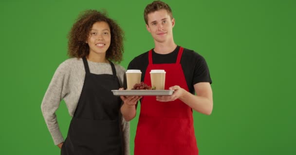 Portret dwóch kelnerów na zewnątrz ciężarówki z jedzeniem lub kawiarni z tacą z jedzeniem i napojami uśmiechniętymi na zielonym ekranie. Na zielonym ekranie do klucza lub kompozycji. - Materiał filmowy, wideo