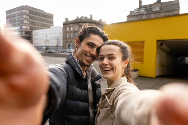 A front-view shot of a young couple standing together taking a selfie, they are in love. - Fotoğraf, Görsel