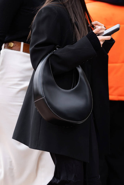 Milan, Italy - September, 21, 2022: woman wears black leather staud mini moon handbag, street style outfit details - Фото, зображення