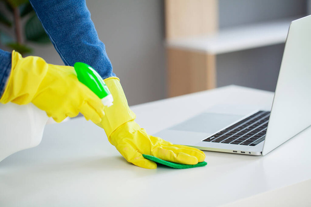Young female worker cleaning office in yellow gloves. - Photo, Image