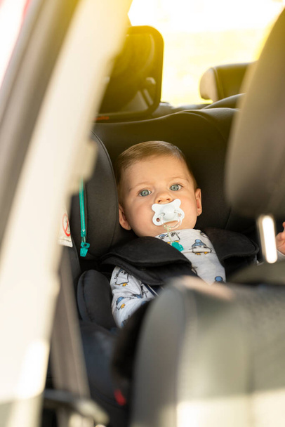 Ritratto di bambino nel seggiolino auto con ciuccio, foto verticale - Foto, immagini