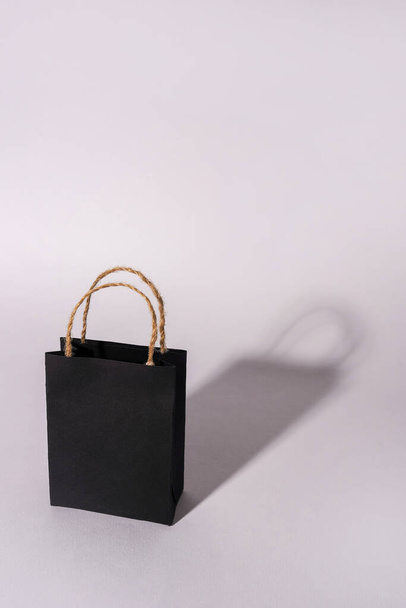 Schwarze Einkaufstasche mit Schatten auf weißem Hintergrund, Kopierraum, Black-Friday-Konzept - Foto, Bild