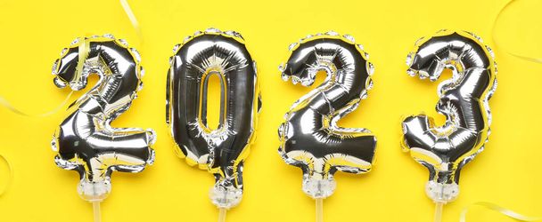 Figura 2023 fatto di palloncini d'argento su sfondo giallo - Foto, immagini