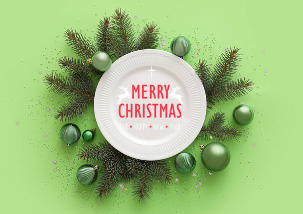 Tarjeta de felicitación navideña con plato y decoraciones sobre fondo verde - Foto, imagen
