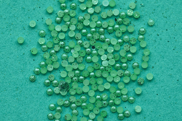 Heap of beads and glitter on mint background - Valokuva, kuva