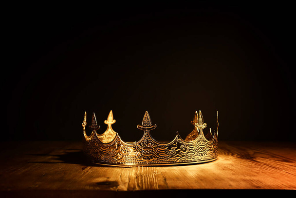 low key image of beautiful queen or king crown over wooden table. vintage filtered. fantasy medieval period - Foto, Imagen