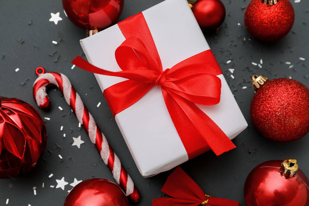 Christmas gift with beautiful decorations on dark background, closeup - Zdjęcie, obraz