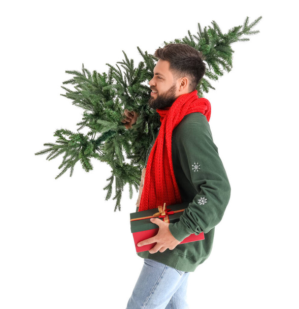 Schöner Mann mit Weihnachtsbaum und Geschenk auf weißem Hintergrund - Foto, Bild