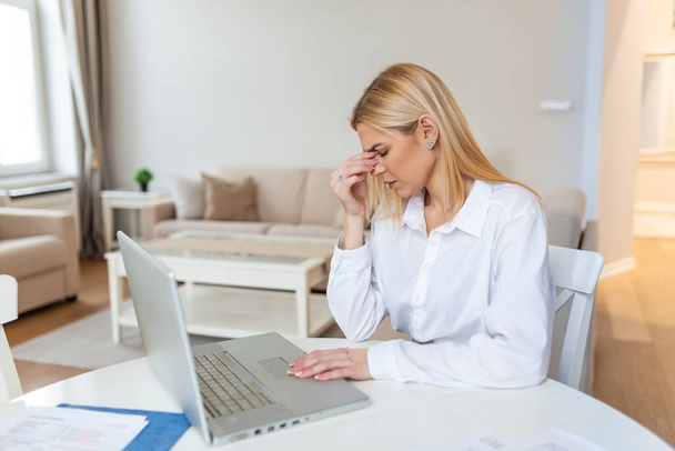 Fiatal csalódott nő dolgozik íróasztal előtt laptop szenved a krónikus mindennapi fejfájás, online, kezelés, egy orvosi konzultáció, az elektromágneses sugárzás, a beteg fizet kinevezéséről - Fotó, kép