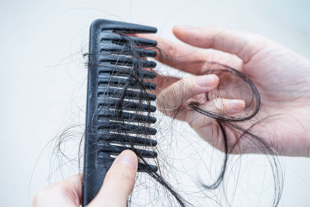 Asian woman have problem with long hair loss attach to comb brush. - Foto, Imagem