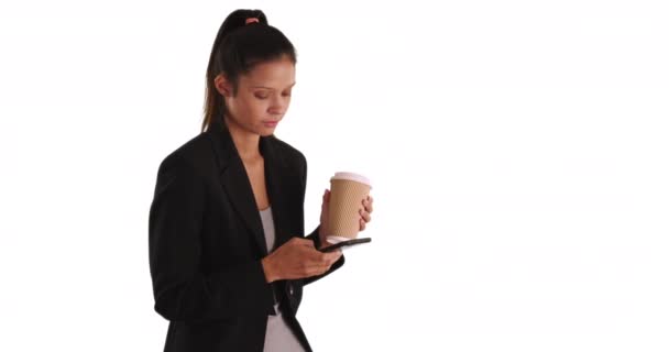 Junge professionelle Frau SMS-Nachrichten und hält Papier zu gehen Kaffeetasse auf weißem Hintergrund mit Kopierraum. Millennial-Geschäftsfrau, die Tee trinkt und per Handy SMS schreibt. 4k - Filmmaterial, Video