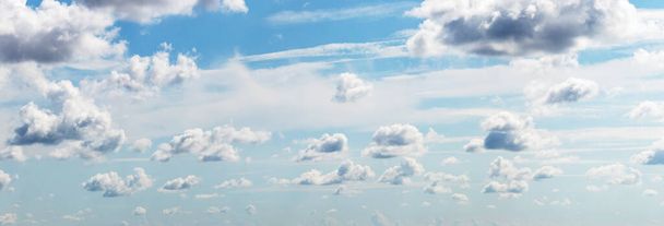 Μεγάλα και μικρά άσπρα σύννεφα στον γαλάζιο ουρανό σε ηλιόλουστο καιρό - Φωτογραφία, εικόνα