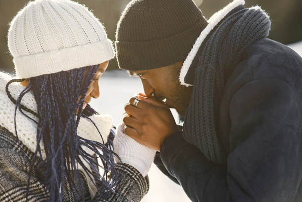 People walks outside. Winter day. African couple - Фото, изображение