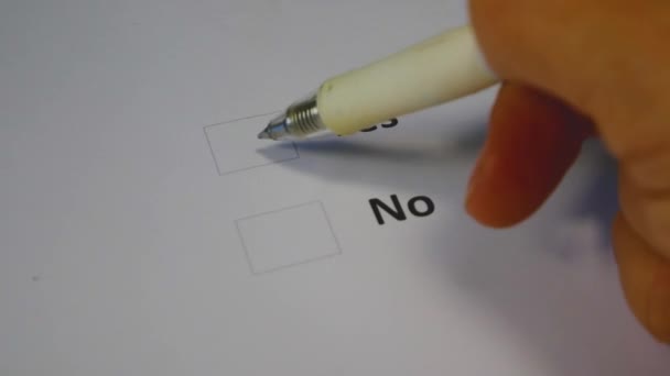 A hand with a pen puts a mark near the Yes column in the paper ballot. U.S. Senate midterm elections. Expression of will at polling stations in November in the United States - Footage, Video