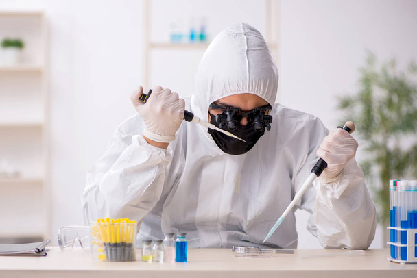 Молодий хімік працює в лабораторії під час пандемії
 - Фото, зображення