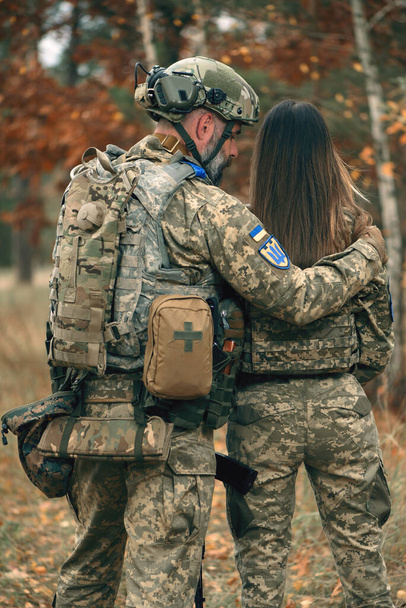 Ukrainan sotilaat mies ja nainen pukeutunut sotilaallinen univormu etulinjassa. Pariskunta sodassa Venäjän hyökätessä Ukrainaan. Rakkaus, yhdessä oleminen ja tuen käsite. Taustakuva - Valokuva, kuva