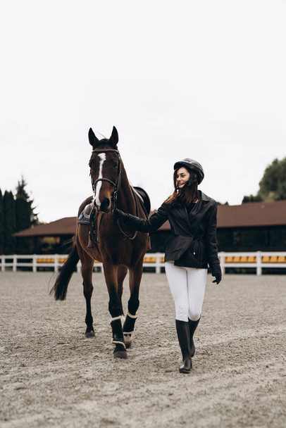 Concursos ecuestres. Una mujer y un caballo se preparan para una carrera. Foto de alta calidad - Foto, Imagen