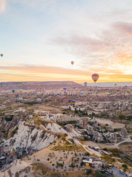 Spectacular drone view of hot air balloons flying over the underground city and fairy chimneys valley in Nevsehir, Goreme, Cappadocia Turkey. High quality photo  - Photo, image
