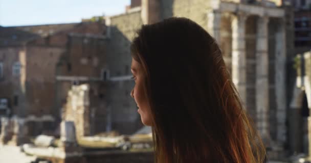 Вид сбоку симпатичной туристки, посещающей Римский форум. Женщине нравится отдыхать в Риме, осматривать достопримечательности и знакомиться с городом. 4k - Кадры, видео