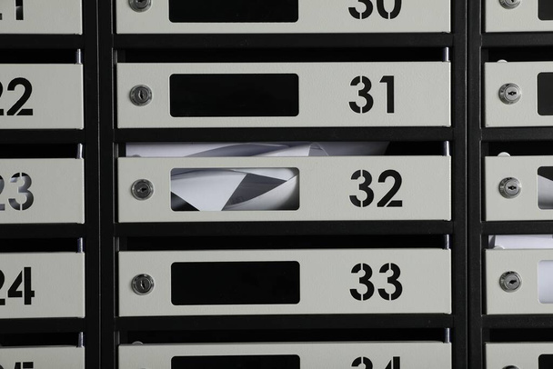 New mailboxes with keyholes, numbers and receipts as background - Foto, immagini