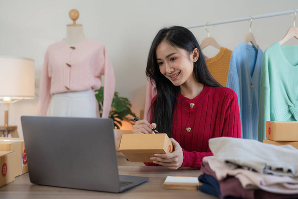 Rozpoczęcie działalności małe przedsiębiorstwo przedsiębiorca niezależny Azji kobieta za pomocą laptopa z pudełkiem Wesoły sukces online marketing opakowanie pudełko i dostawa pomysł MŚP. - Zdjęcie, obraz
