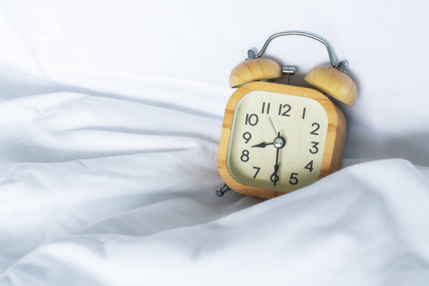 Relógio despertador às 8 na cama com cobertor branco - Foto, Imagem