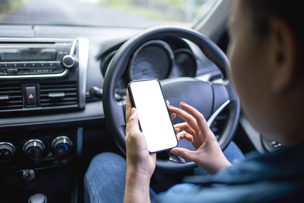 Il conducente usa il telefono durante la guida. Schermo isolato per il mockup. Visualizzazione navigazione auto in background. - Foto, immagini
