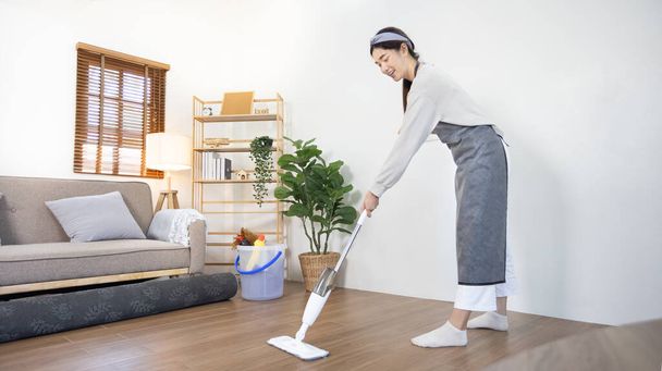 Krásná čistá hospodyňky je čištění podlahy v obývacím pokoji, velký úklid v domě, odstraňuje bakterie a nečistoty a hluboké skvrny, Úklid manželky v domácnosti, Udržování její domov čistý, Domácí hygiena. - Fotografie, Obrázek