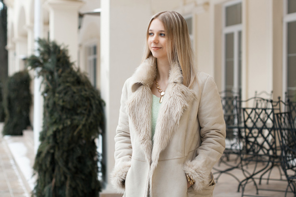 Belle fille dans la veste d'hiver debout près du bâtiment
 - Photo, image