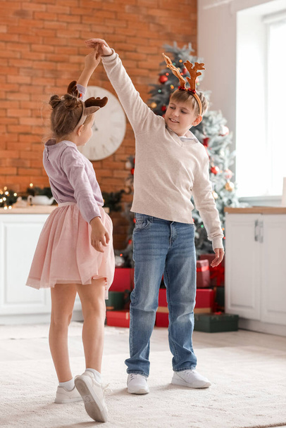 Little children dancing in kitchen on Christmas eve - Valokuva, kuva