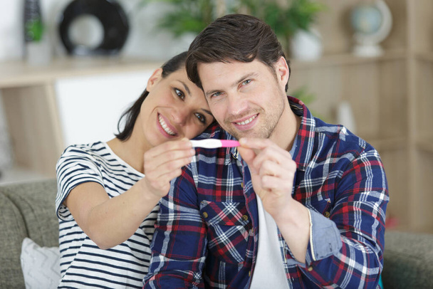 happy couple holding pregnancy test - Foto, afbeelding