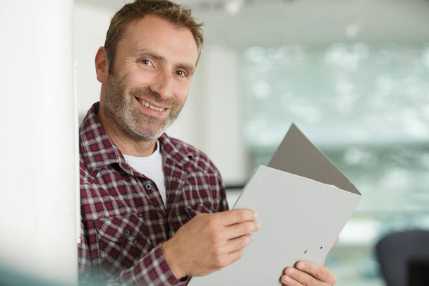 picture of man smiling holding an open folder - Valokuva, kuva
