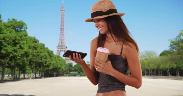 Hermosa turista con mensajes de texto de café cerca de la Torre Eiffel. Elegante chica caucásica con sombrero de sombrero de sombrero usando el teléfono móvil en París. 4k - Imágenes, Vídeo