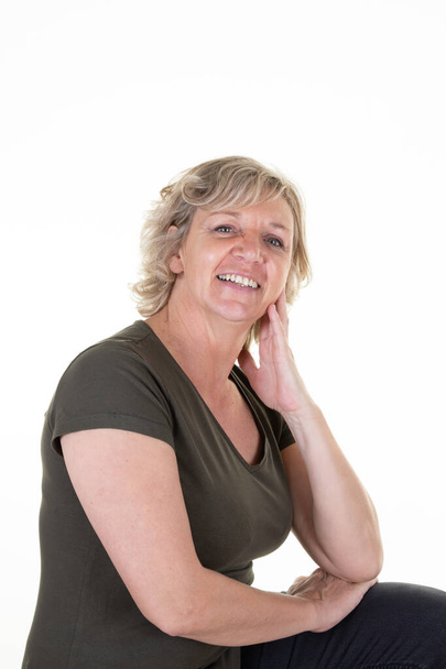 glimlachen volwassen vrouw blond poseren in wit studio achtergrond - Foto, afbeelding
