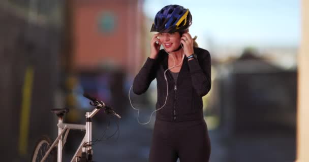 Femme caucasienne d'âge moyen en tenue de sport en utilisant un appareil post-entraînement avec vélo dans l'allée. Femme blanche utilisant la technologie après une balade à vélo à l'extérieur. 4k - Séquence, vidéo