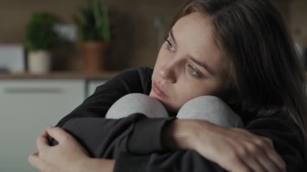 Traurige junge Frau, die zu Hause sitzt und denkt. Aufnahme mit roter Heliumkamera in 8K.    - Filmmaterial, Video