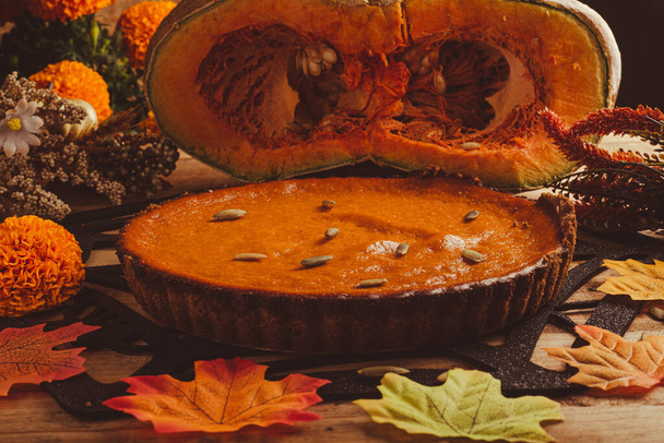 Pumpkin pie on wooden table. Dessert for thanksgiving dinner and pumpkin on wooden table. - Photo, Image