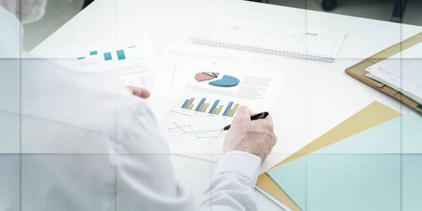 Бизнесмен проверяет финансовые графики, в офисе, геометрический шаблон - Фото, изображение