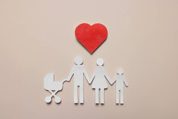 Paper family figures and red heart on beige background, flat lay. Insurance concept - 写真・画像