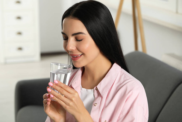 Young woman with glass of water indoors. Refreshing drink - Φωτογραφία, εικόνα