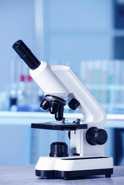 Modern medical microscope on gray table in laboratory - Φωτογραφία, εικόνα