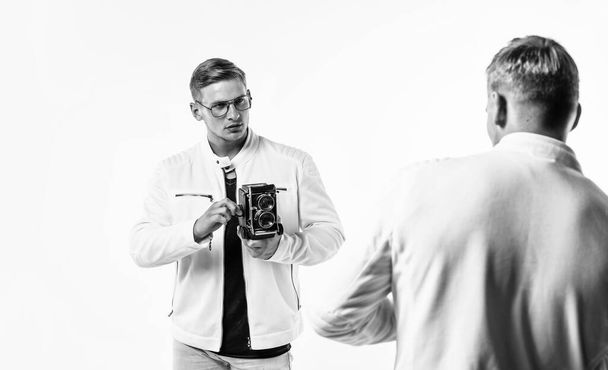 twin brothers men photographer in white casual clothes look alike use vintage photo camera, photographing. - Zdjęcie, obraz