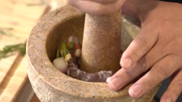 Chef pounding Spicy shrimp paste in a brown stone mortar. - Footage, Video